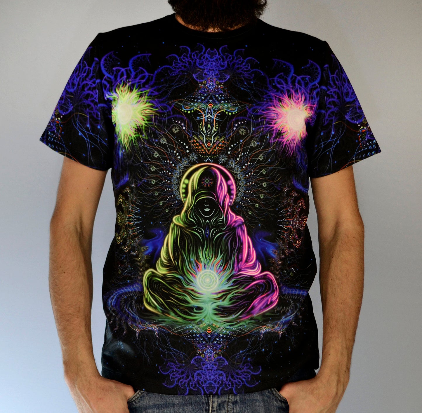 Adept Psychedelic art print featuring t-shirt with a colorful illustration of a shaman in lotus position meditating in front of a mandala glowing under blacklight